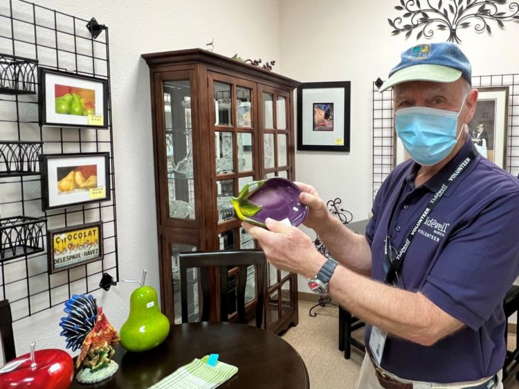 A Tidewell Treasures volunteer shows off items for sale at the new location in Sarasota